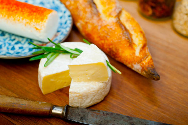 istock French cheese and fresh  baguette on a wood cutter 1355950438
