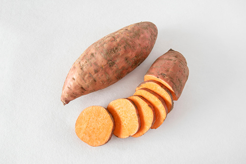 Close-up of whole and sliced sweet potatoes