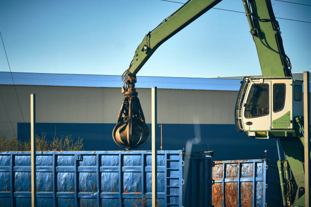 istock Crane loads dipper truck with scrap metal 1355950702