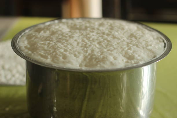 Risen and puffed up fermented appam batter with tiny fermentation holes on top