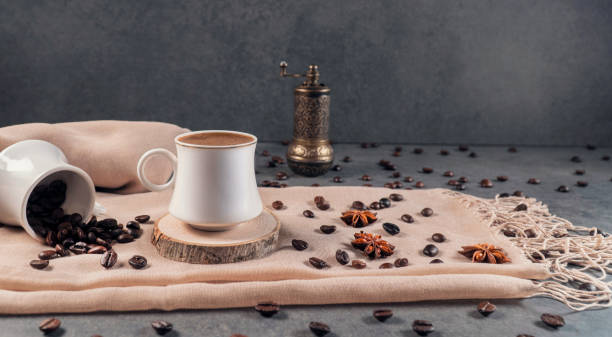 chicchi di caffè, vecchio macinino manuale e caffè turco su sfondo grigio scuro. un'immagine presentata con chicchi di caffè su uno scialle color crema. - coffee coffee bean coffee grinder cup foto e immagini stock