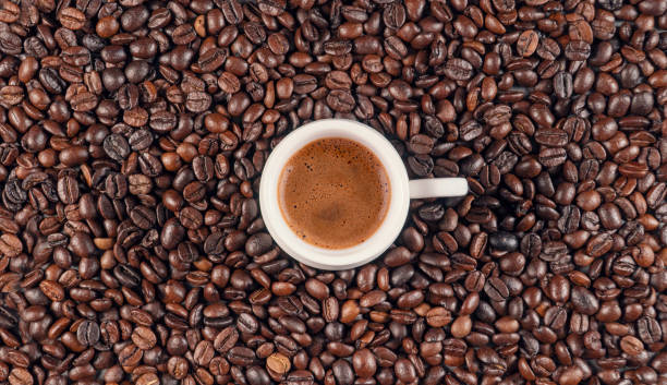 vista dall'alto di un caffè turco in una tazza bianca. ci sono chicchi di caffè sullo sfondo. - coffee bean caffeine macro food foto e immagini stock