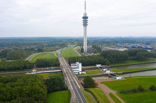 Drone photography. Communication Tower of a radio mast, tall structure designed to support antennas for telecommunication and broadcasting, television, agianst a blue sky with clouds