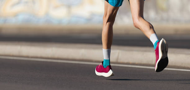 istock Athlete runner feet running on road close up on shoe 1355957669
