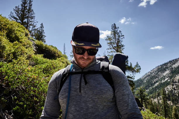 Man hikes along forested trail, in early autumn