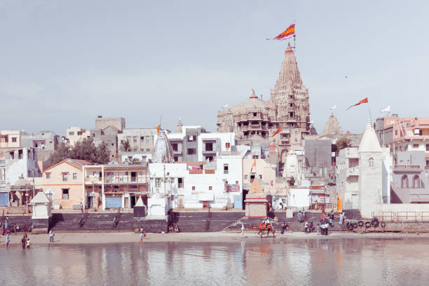 Dwarka, India - January 2, 2016 : people walk along Gomti riverbank. View of Gomti Ghat and Krishna temple Shree Dwarkadhish