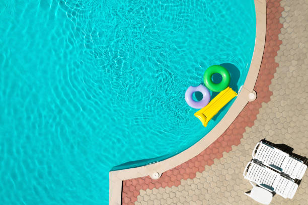 istock Inflatable rings and mattress floating in swimming pool, top view with space for text. Summer vacation 1355964606