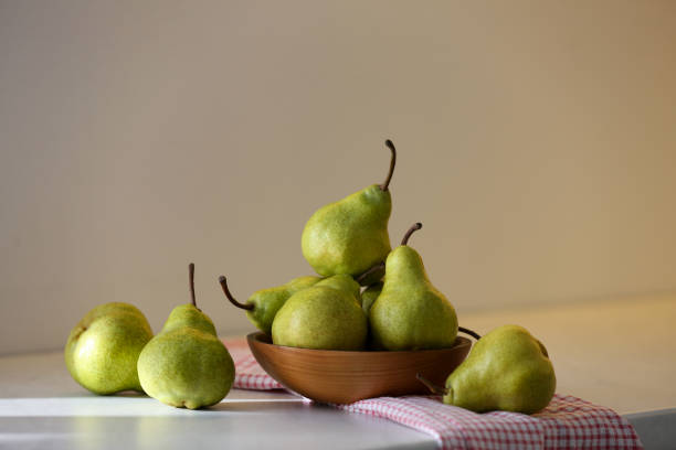 istock Bowl with fresh ripe pears on white table 1355965275