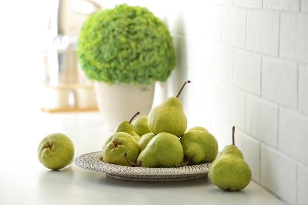 istock Fresh ripe pears on white countertop in kitchen 1355965485
