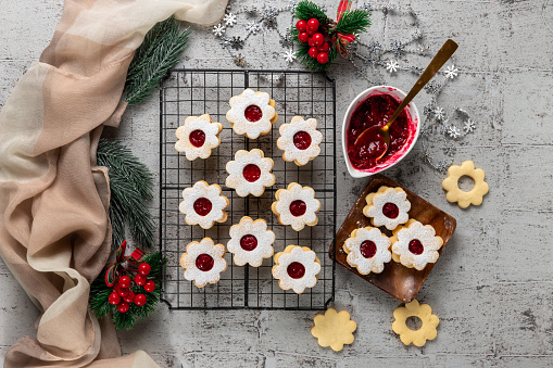 Linzer Christmas or New Year cookies filled with jam and dusted with sugar on gray background.