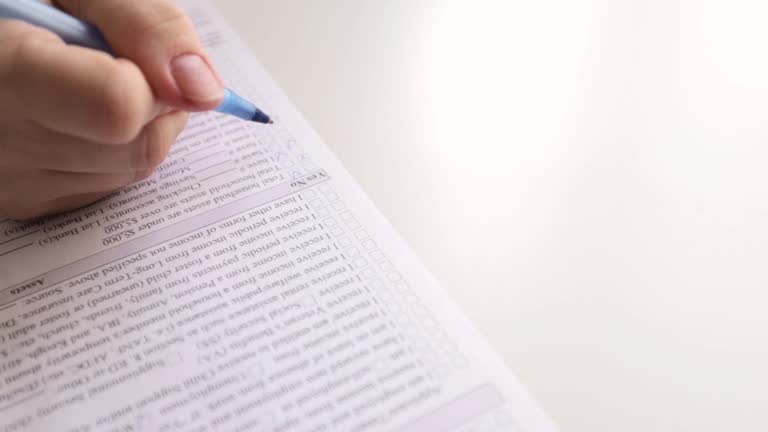 Drawing up a tax return. Hands holding a pen for signature