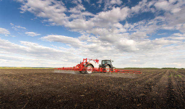 istock Tractor spraying pesticides on field  with sprayer 1355965768