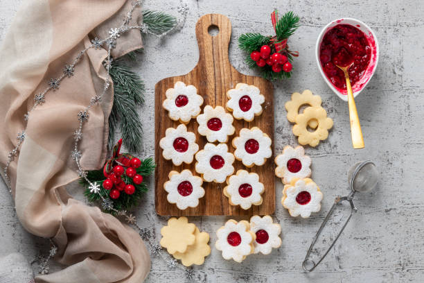 linzer christmas or new year cookies filled with jam and dusted with sugar on gray background. - cookie christmas shortbread food imagens e fotografias de stock