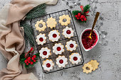 Linzer Christmas or New Year cookies filled with jam and dusted with sugar on gray background.