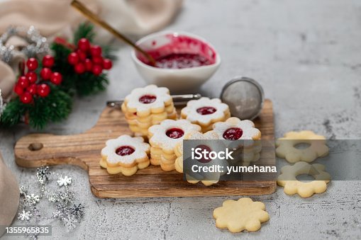 istock Linzer Christmas or New Year cookies filled with jam and dusted with sugar on gray background. 1355965835