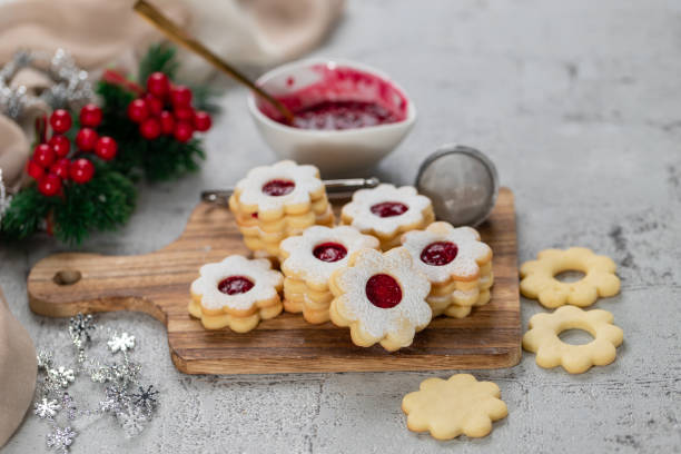 Linzer Christmas or New Year cookies filled with jam and dusted with sugar on gray background. stock photo
