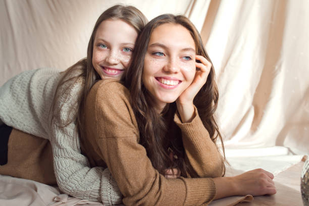 istock sisters having fun on beige color textile background 1355965855