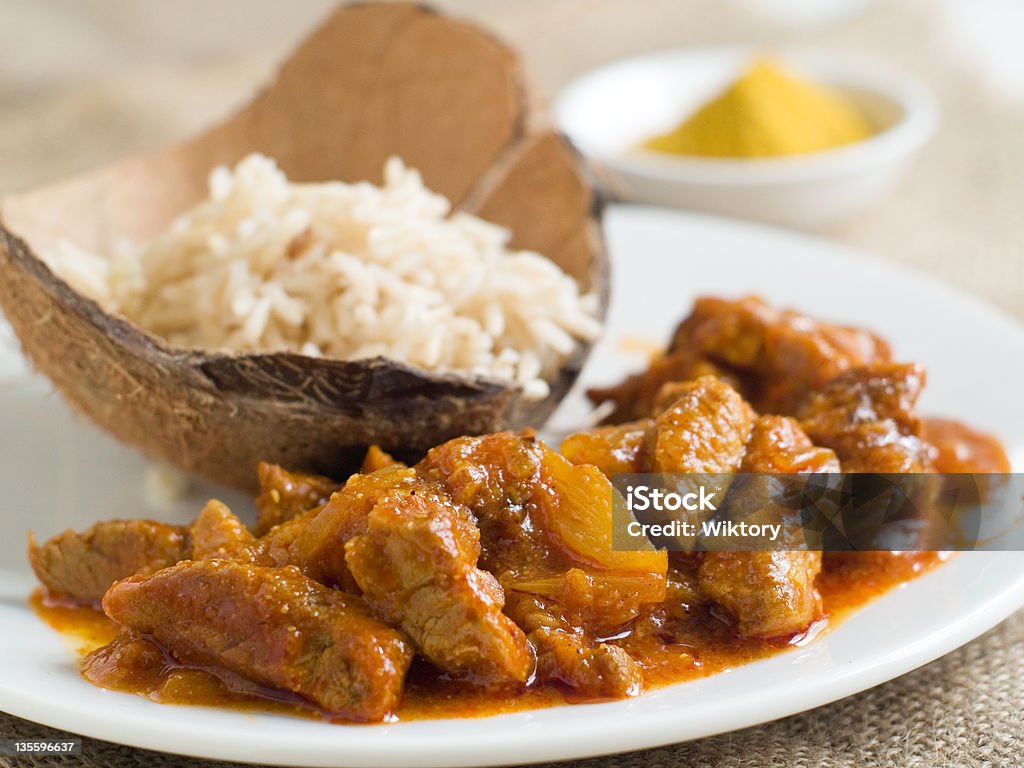 A large curry served with basmati rice Meat curry  with rice, selective focus. Bamboo - Material Stock Photo