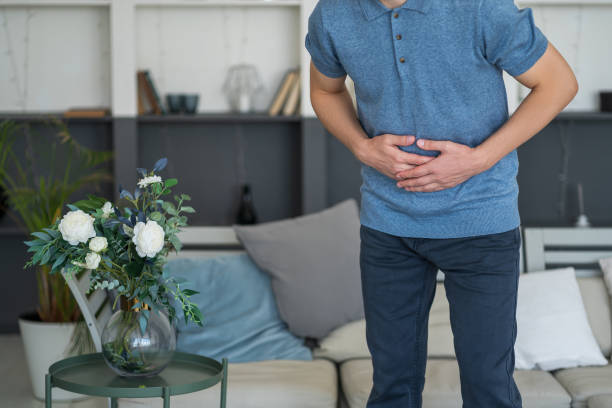 Stomach ache, man with abdominal pain suffering at home stock photo