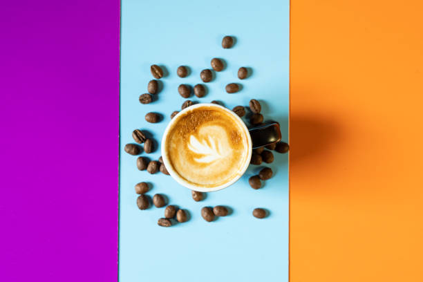 istock Cup of coffee with beans on colorful background. 1355970698
