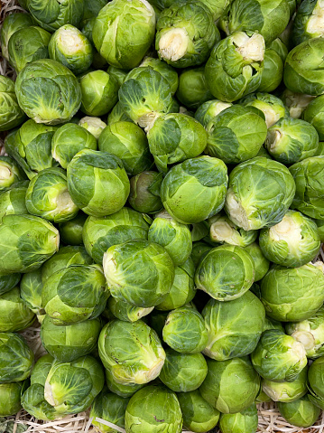 Stock photo showing a group of fresh green brussels sprouts being sold in a fruit and vegetable store.