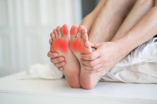 dolore ai piedi, uomo che soffre di mal di piedi all'interno della casa - podiatrist chiropractor massaging human foot foto e immagini stock