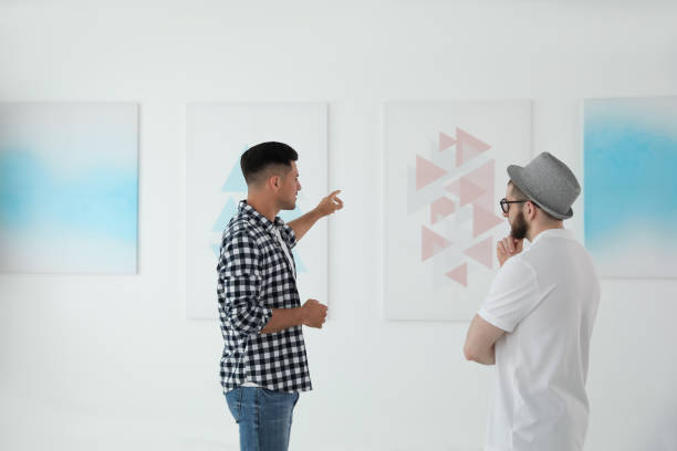 istock Men discussing artworks at exhibition in art gallery 1355971803