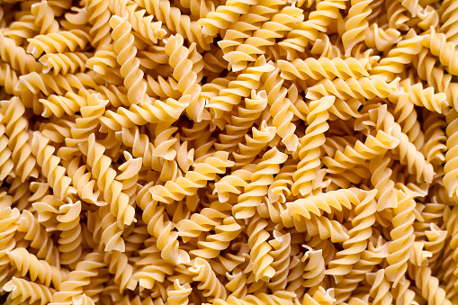 Full-frame close-up on a stack of uncooked fusilli.