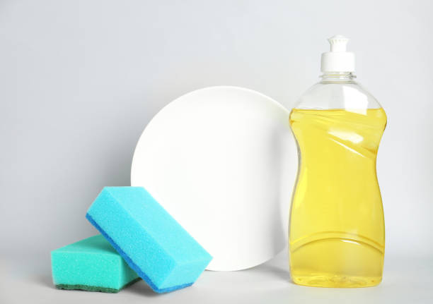 istock Detergent, plate and sponges on light background. Clean dishes 1355971888
