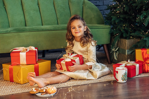 Cute blue-eyed girl holding a christmas present