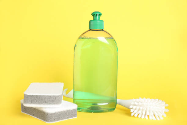istock Detergent, brush and sponges on yellow background 1355972354