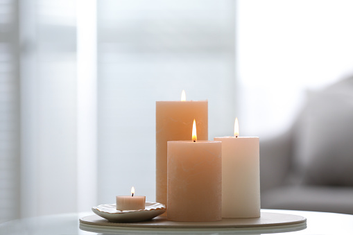 Drops of water on window glass and burning candle