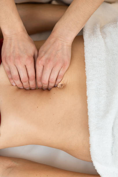 Hands of physiotherapist checking diastasis recti on belly of postpartum woman Top view of an unrecognizazble physiotherapist checking diastasis recti on belly of postpartum woman. shiatsu photos stock pictures, royalty-free photos & images