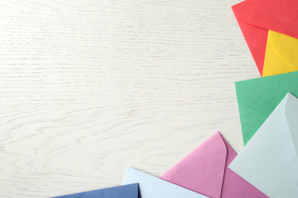istock Colorful paper envelopes on white wooden background, flat lay. Space for text 1355973524