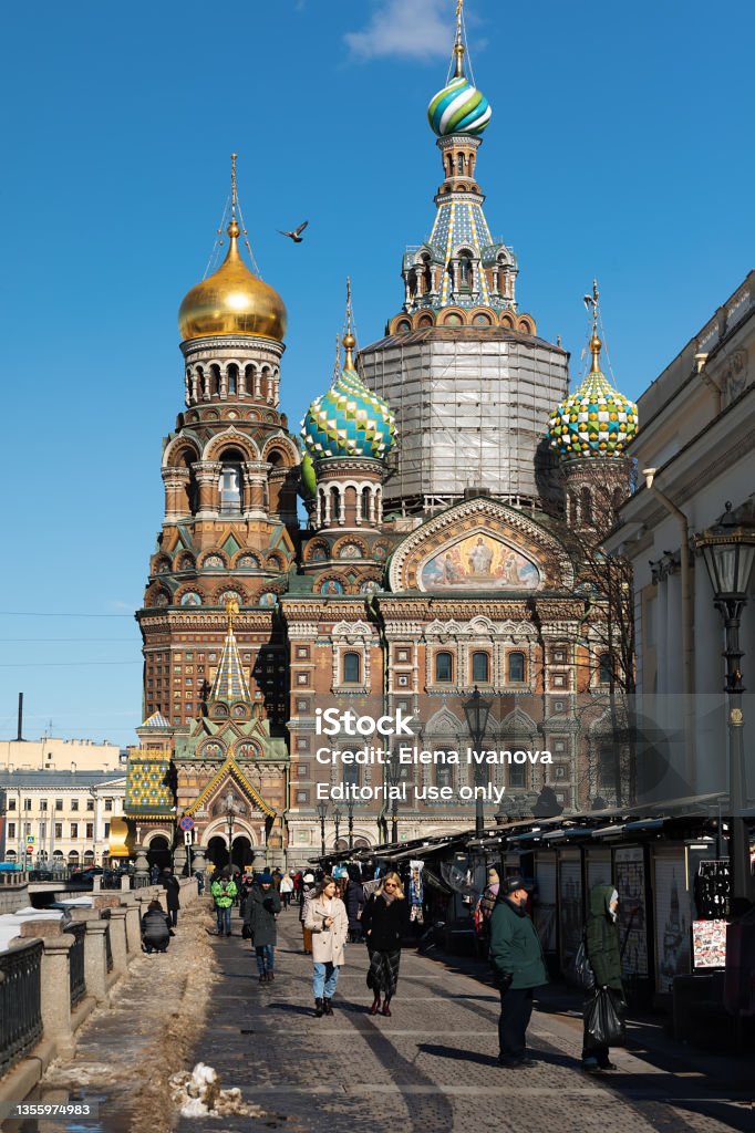 People walking on cobblestone pavement among historic buildings Saint Petersburg, Russia, March 2021: People walking on cobblestone pavement among historic buildings, Savior on the Spilled Blood Adult Stock Photo