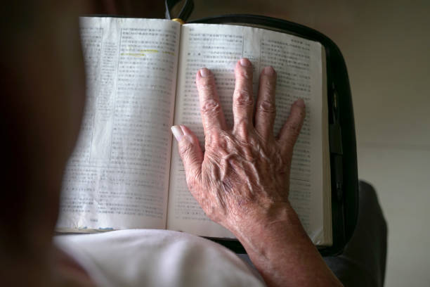 Senior man's hand on top of an open book.