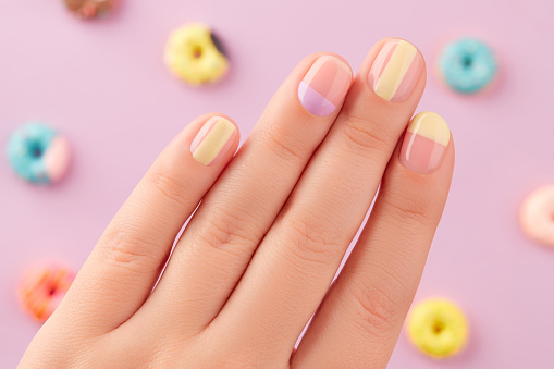 Beautiful yellow lavender manicure on creative background. Fashionable minimal spring summer nail design.