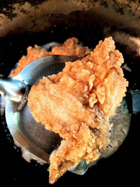 istock Frying Chicken in cooking pan - food preparation. 1355979444