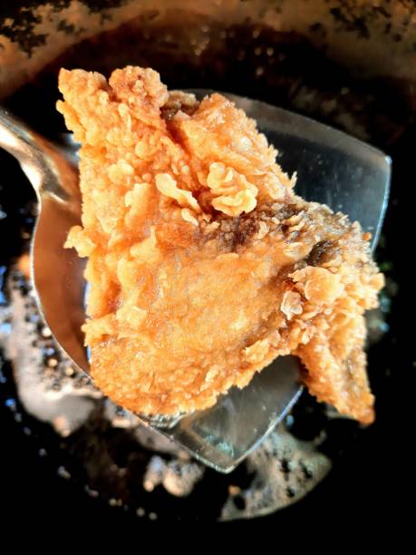 istock Frying Chicken in cooking pan - food preparation. 1355979447