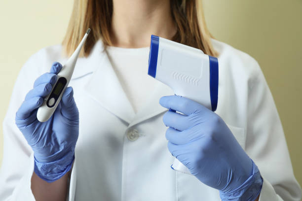 istock Female doctor holds digital thermometers, close up 1355979620