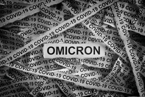 Strips of newspaper with the words Omicron and Covid-19 typed on them. Strips of newspaper with the words Omicron and Covid-19 typed on them. Omicron variant of COVID-19. Black and white. Close up. b117 covid 19 variant stock pictures, royalty-free photos & images