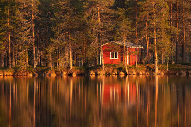 mała i przytulna chata na pustyni z refleksją podczas zachodu słońca nad letnim jeziorem - cottage autumn wood woods zdjęcia i obrazy z banku zdjęć