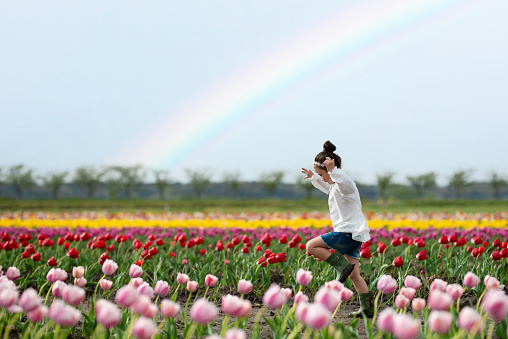 Girl playing in a rainbow flower field