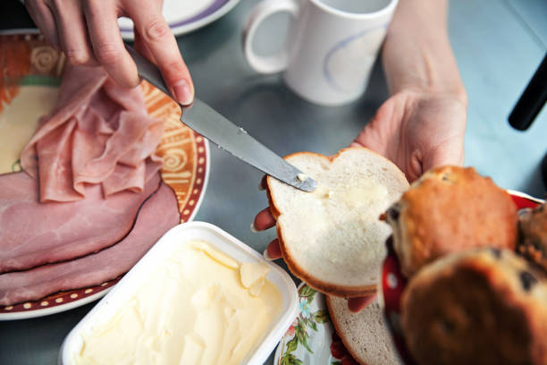 woman eating breakfast - butter toast bread breakfast imagens e fotografias de stock