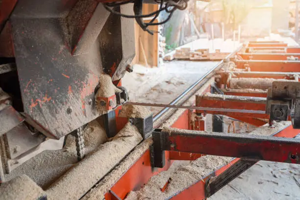 Photo of Sawmill. Old equipment for processing and cutting wood at a sawmill. Woodworking industry