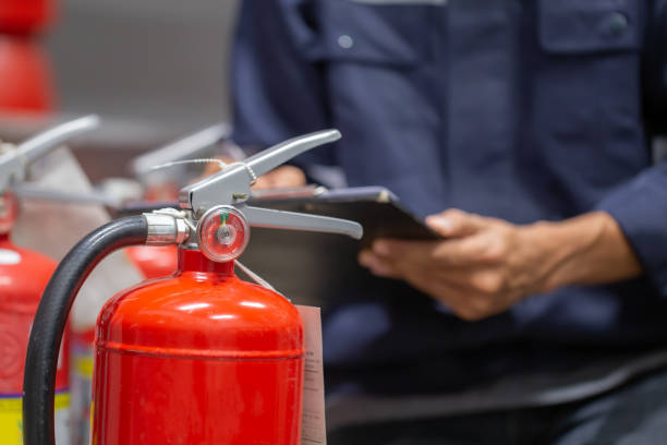 gli ingegneri stanno controllando e ispezionando un serbatoio di estintori nella sala di controllo antincendio per la formazione sulla sicurezza e la prevenzione degli incendi. - sicurezza sul posto di lavoro foto e immagini stock