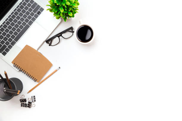 istock White office desk table with blank notebook, computer keyboard and other office supplies. Top view with copy space, flat lay. 1355985107
