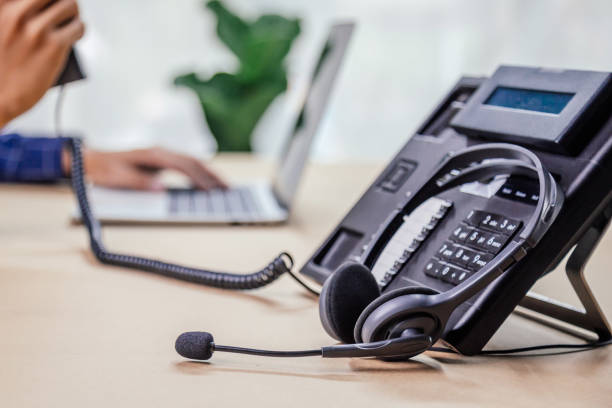 istock Communication support, call center and customer service help desk. telephone devices with VOIP headset in office.Customer service support (call center) concept. 1355985137