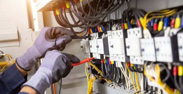 istock Electrician engineer tests electrical installations and wires on relay protection system. Adjustment of scheme of automation and control of electrical equipment. 1355985195