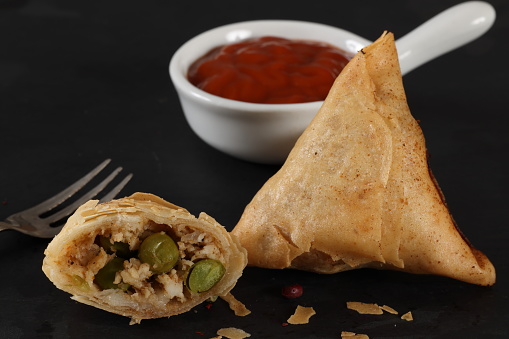 Deep fried Samosa with light crisp pastry filled with cream cheese vegetables herbs and spices. High resolution image 45Mp using Canon EOS R5 with associate macro lens